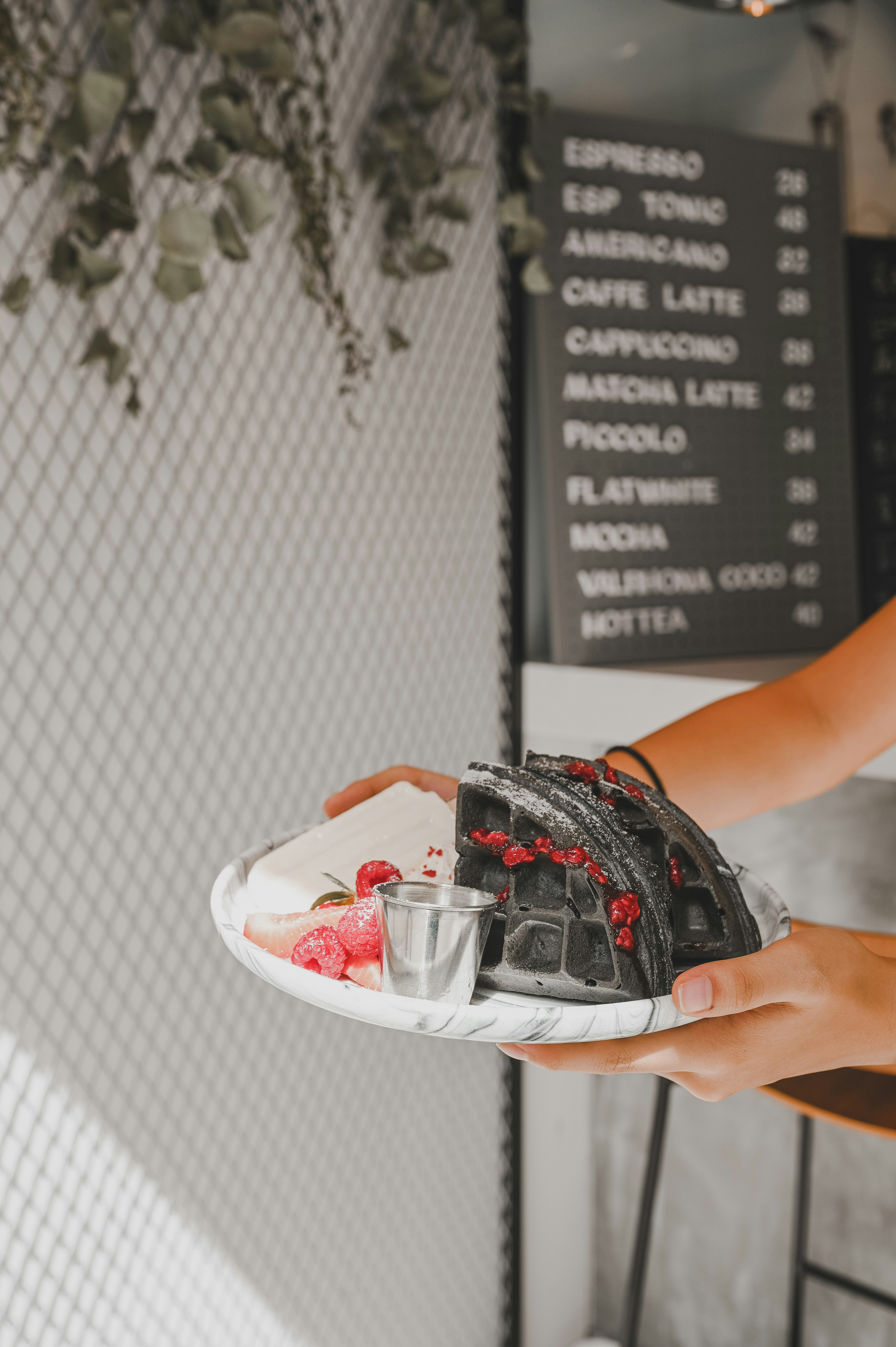 person holding clear glass bowl with black and red nike athletic shoes